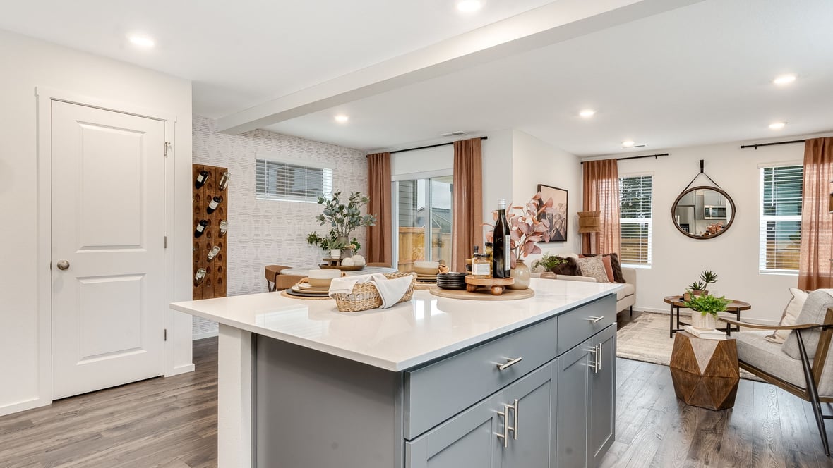 Kitchen with shaker cabinets, quartz counters, stainless steel appliances, pantry, and an island with a breakfast bar