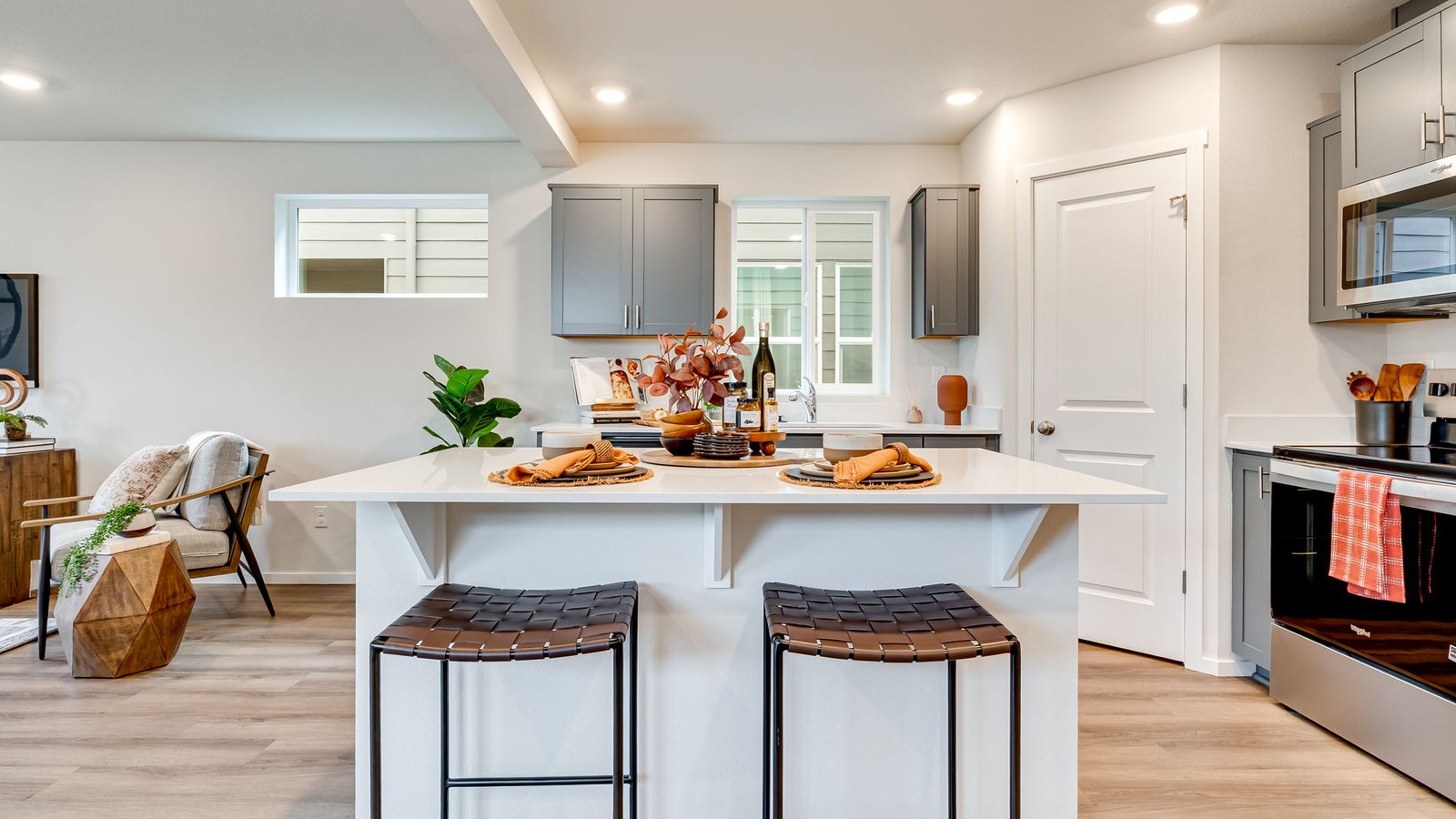 Kitchen with shaker cabinets, quartz counters, stainless steel appliances, pantry, and an island with a breakfast bar