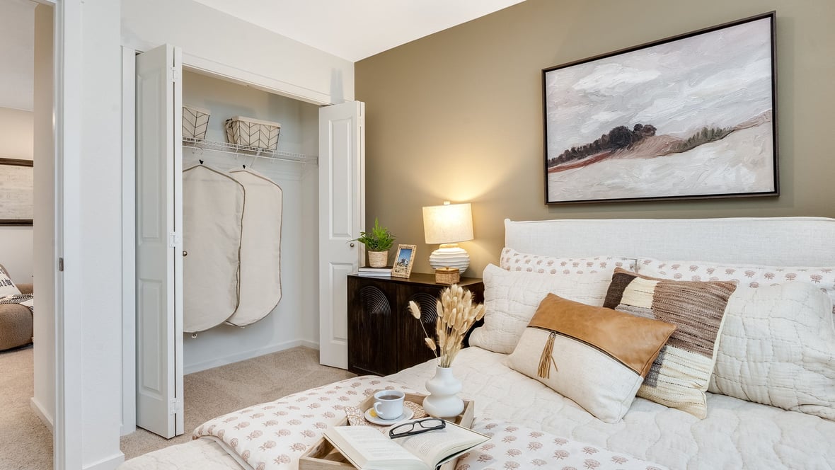 Guest bedroom with wall-to-wall carpet and a closet