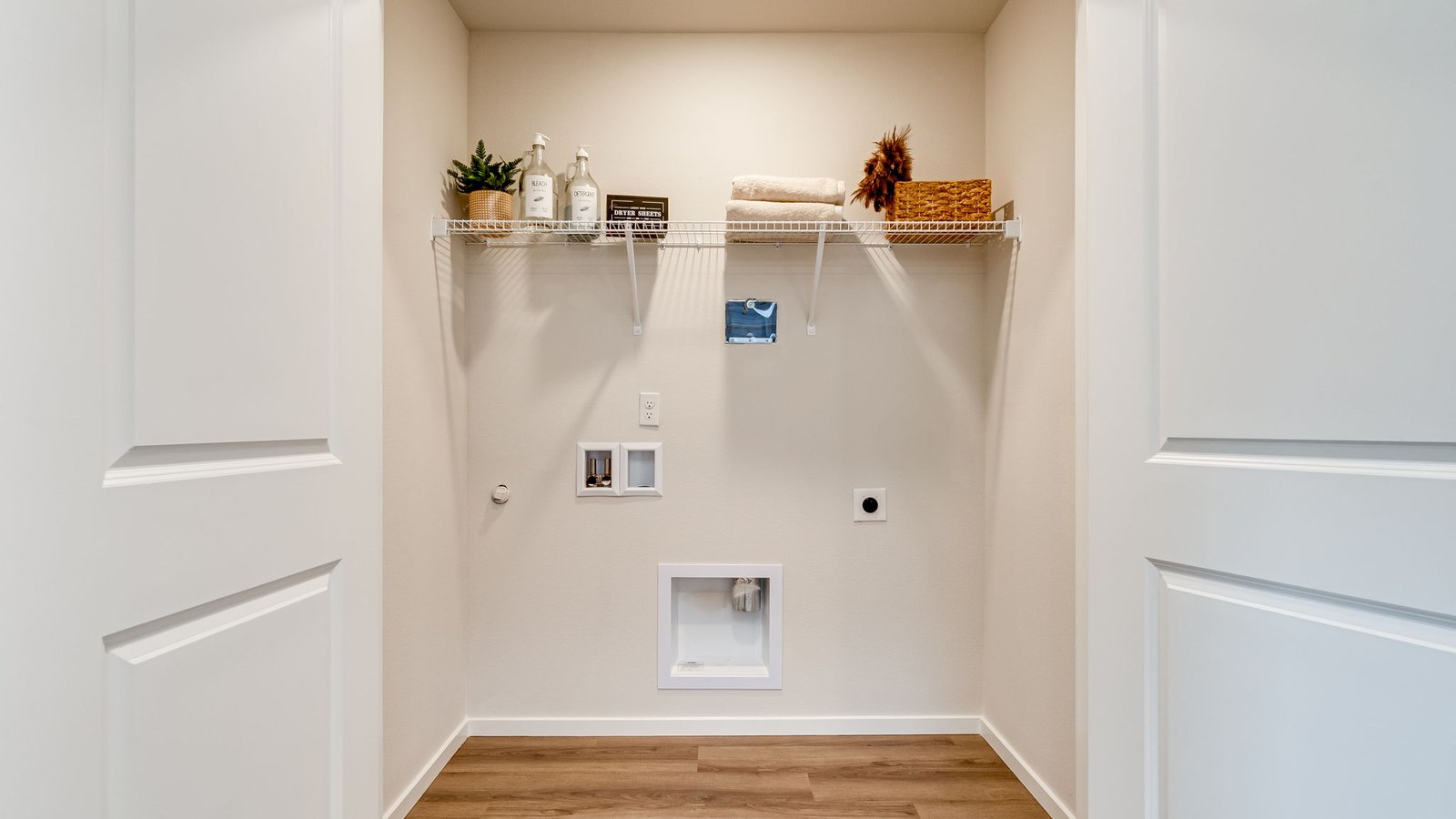 Laundry closet with wire shelves and washer and dryer hookups
