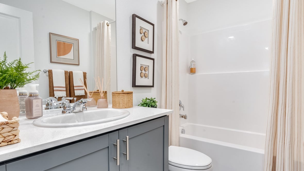 Hall bathroom with combination tub/shower and quartz counters