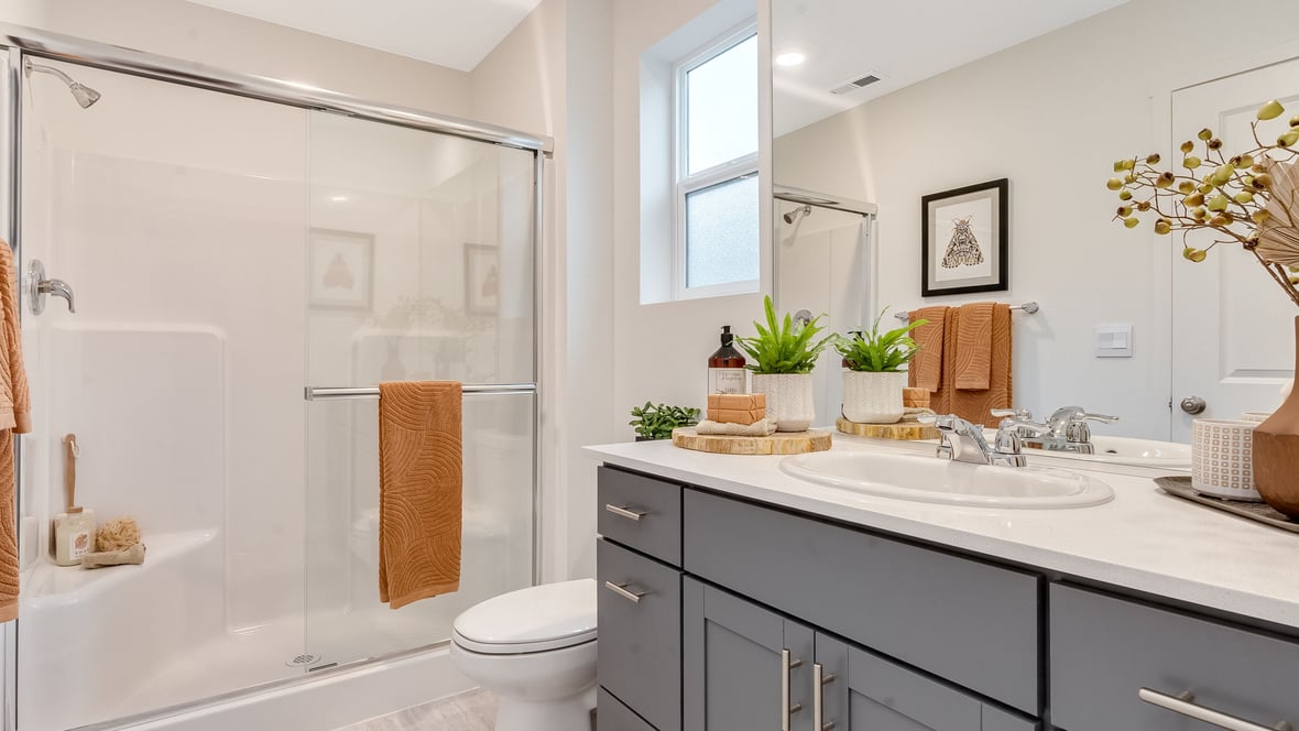 Primary bathroom with quartz counters and a walk-in shower