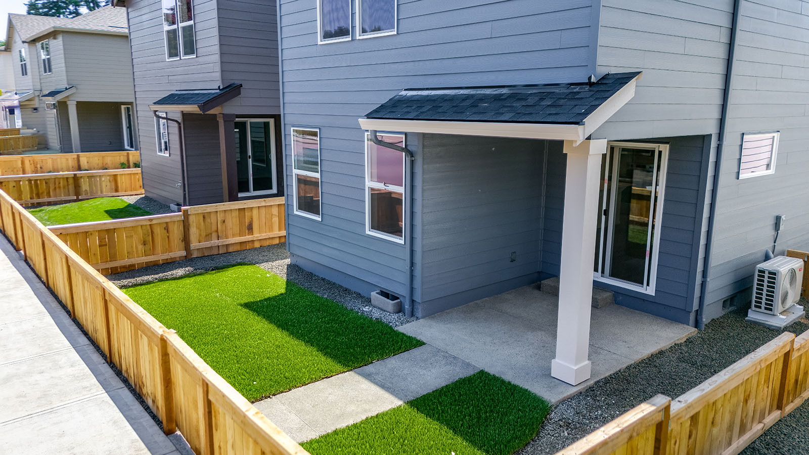 fenced backyard with sod lawn and a patio