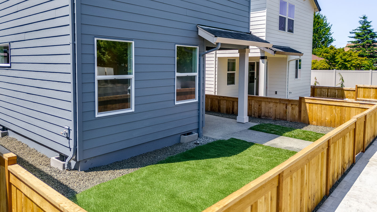 fenced backyard with sod lawn and a patio