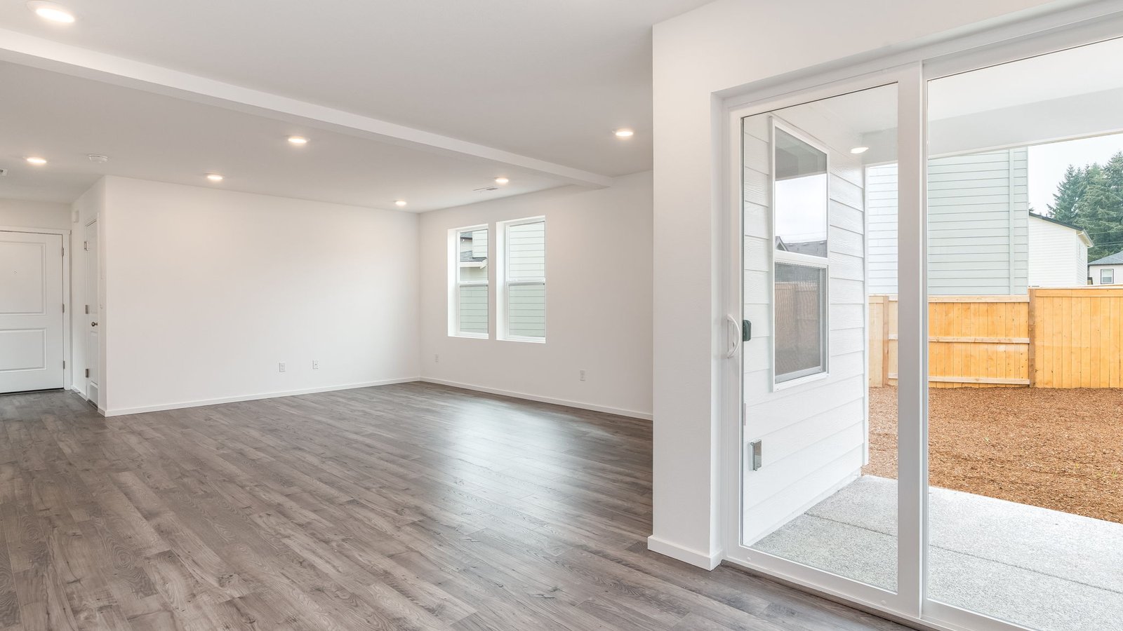 L-shaped kitchen with shaker cabinets, quartz counters, stainless steel appliances, and a pantry