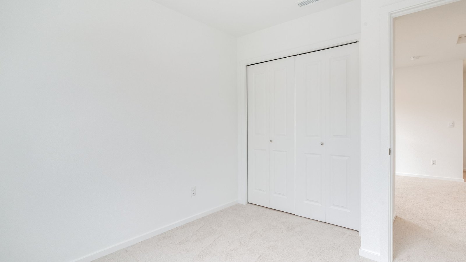 Bedroom with wall-to-wall carpet and a closet