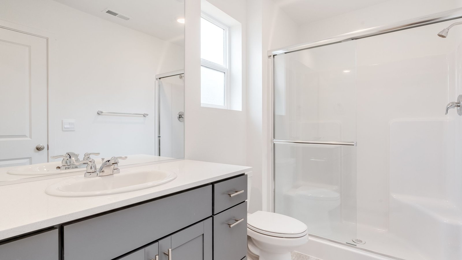 Primary bathroom with quartz counters and a walk-in shower