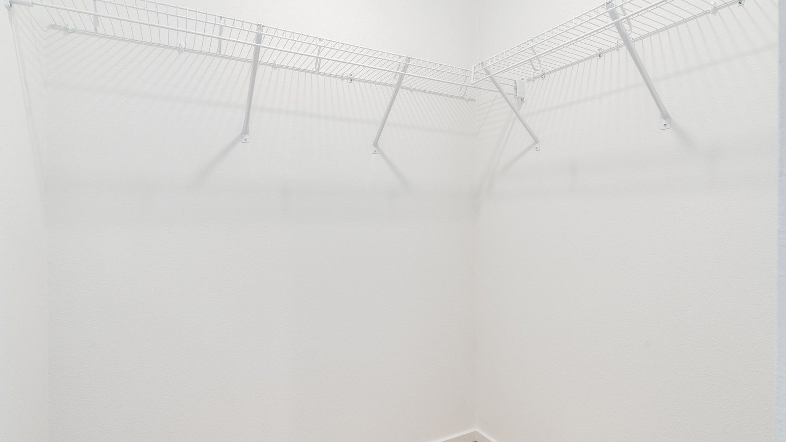 Primary bedroom walk-in closet with wire shelves