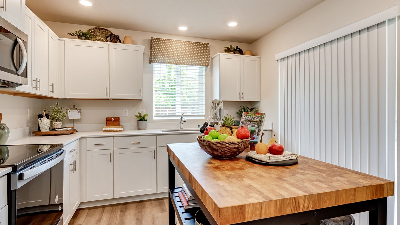 L-shaped kitchen with shaker cabinets, quartz counters, stainless steel appliances, and a pantry