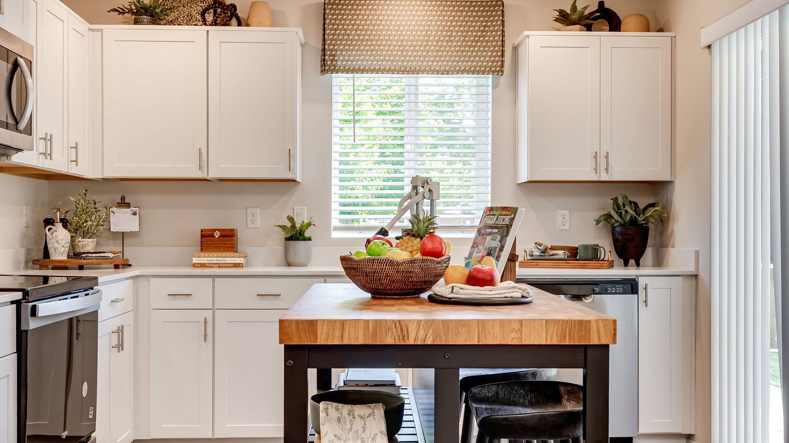 L-shaped kitchen with shaker cabinets, quartz counters, stainless steel appliances, and a pantry