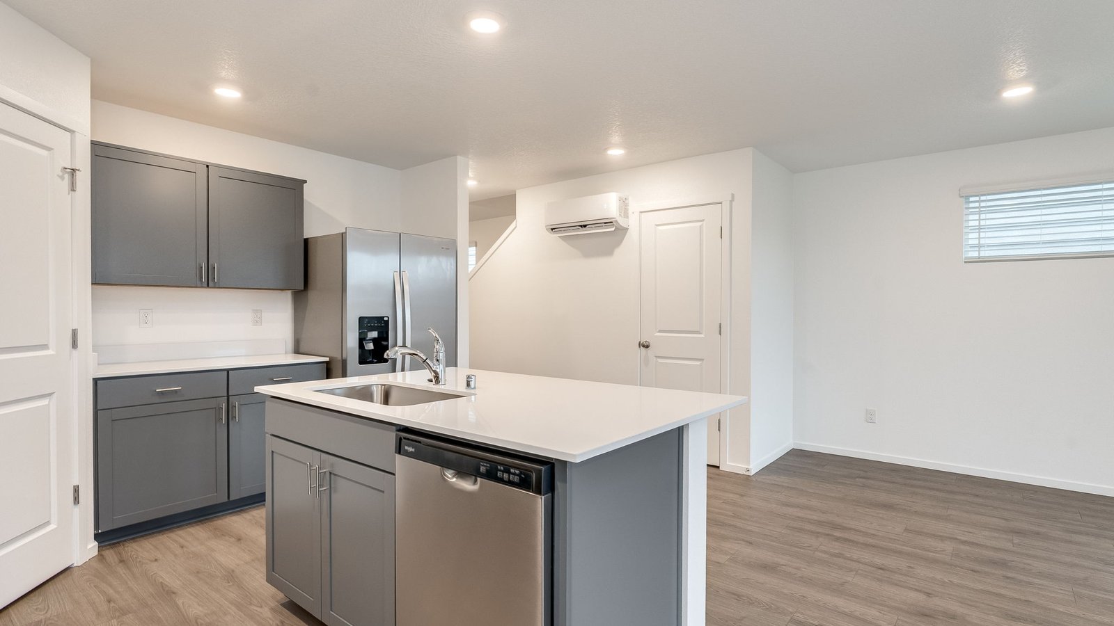 Kitchen with shaker cabinets, quartz counters, stainless steel appliances, pantry, and an island with a breakfast bar