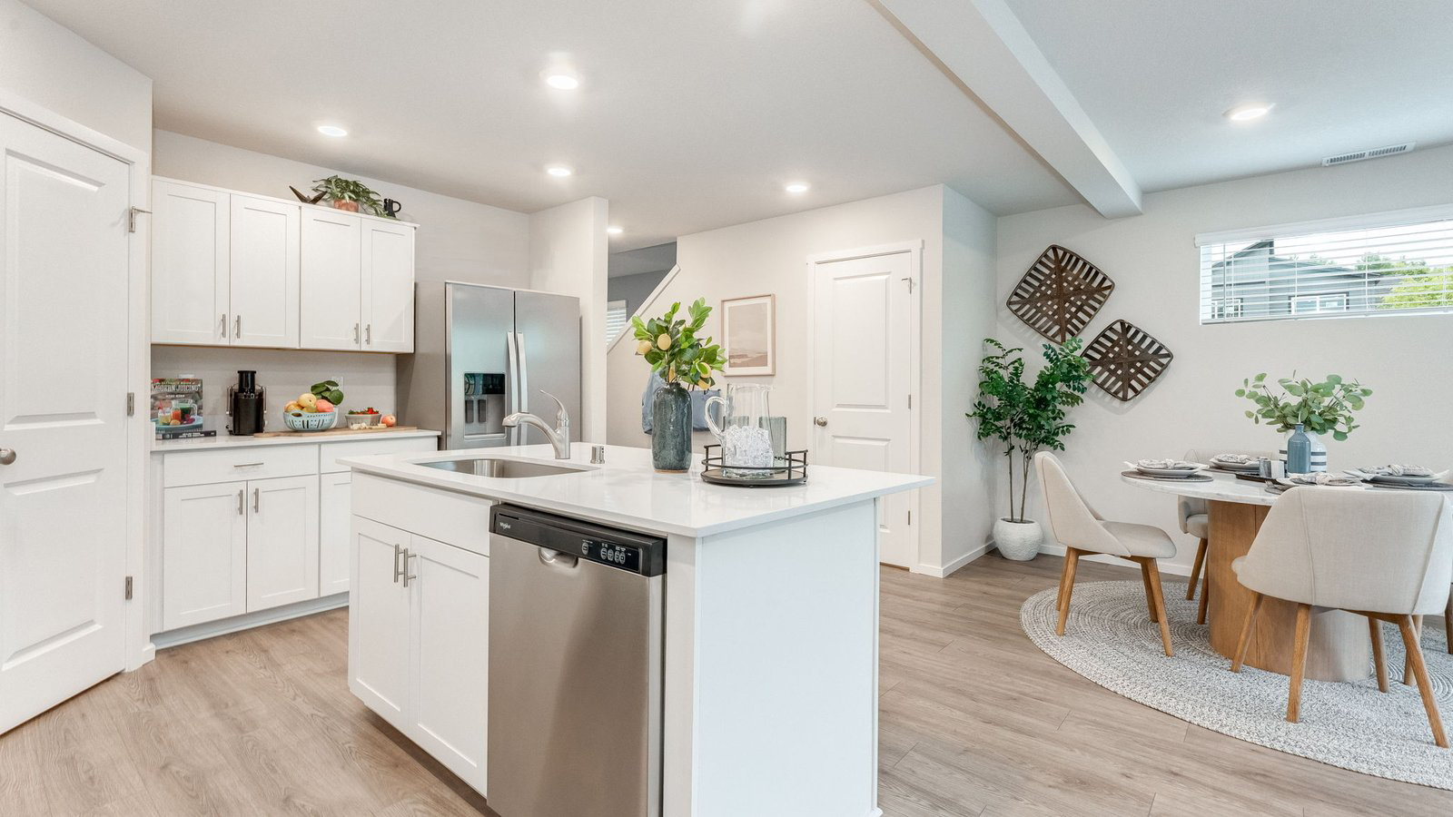 Kitchen with shaker cabinets, quartz counters, stainless steel appliances, pantry, and an island with a breakfast bar