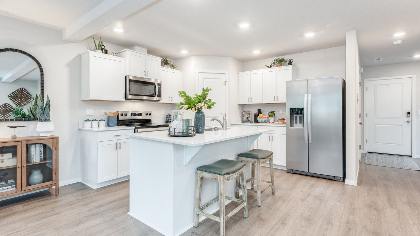 Kitchen with shaker cabinets, quartz counters, stainless steel appliances, pantry, and an island with a breakfast bar