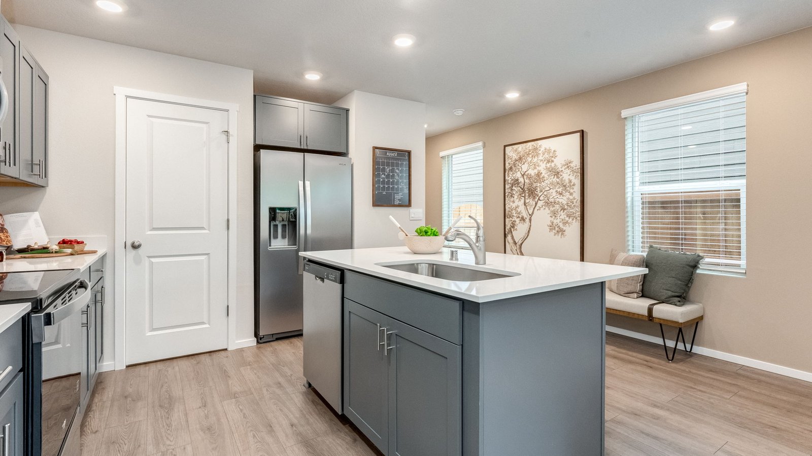 Kitchen with shaker cabinets, quartz counters, stainless steel appliances, pantry, and an island with a breakfast bar