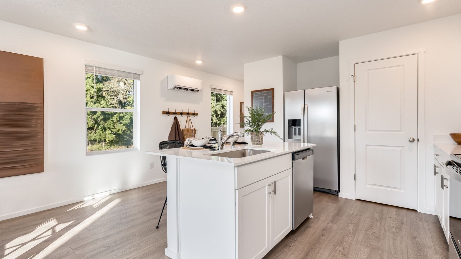 Kitchen with shaker cabinets, quartz counters, stainless steel appliances, pantry, and an island with a breakfast bar