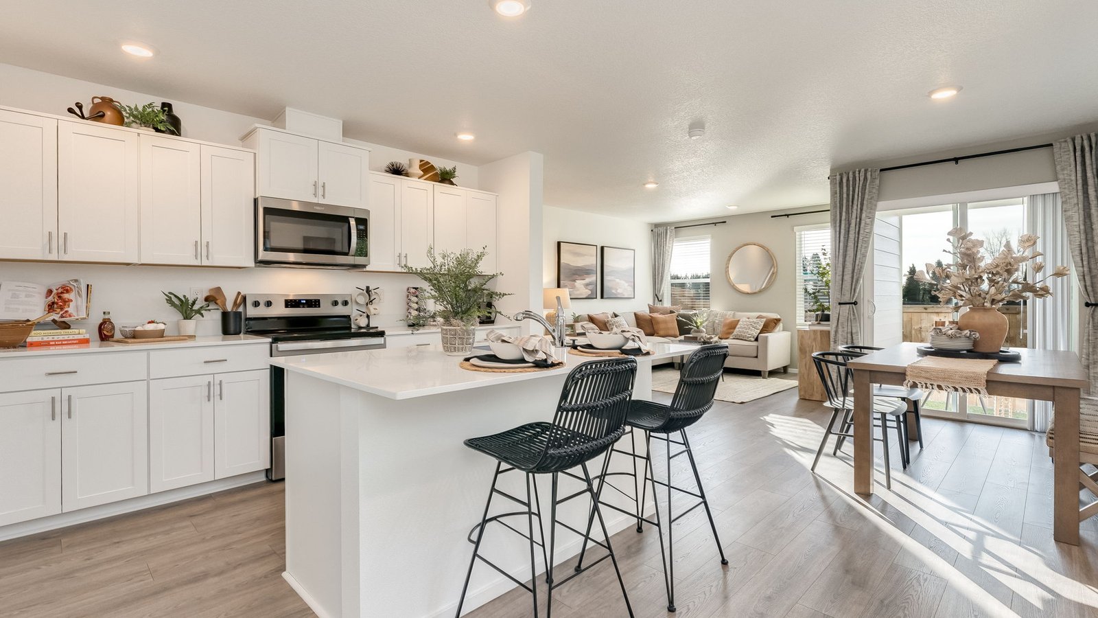Kitchen with shaker cabinets, quartz counters, stainless steel appliances, pantry, and an island with a breakfast bar