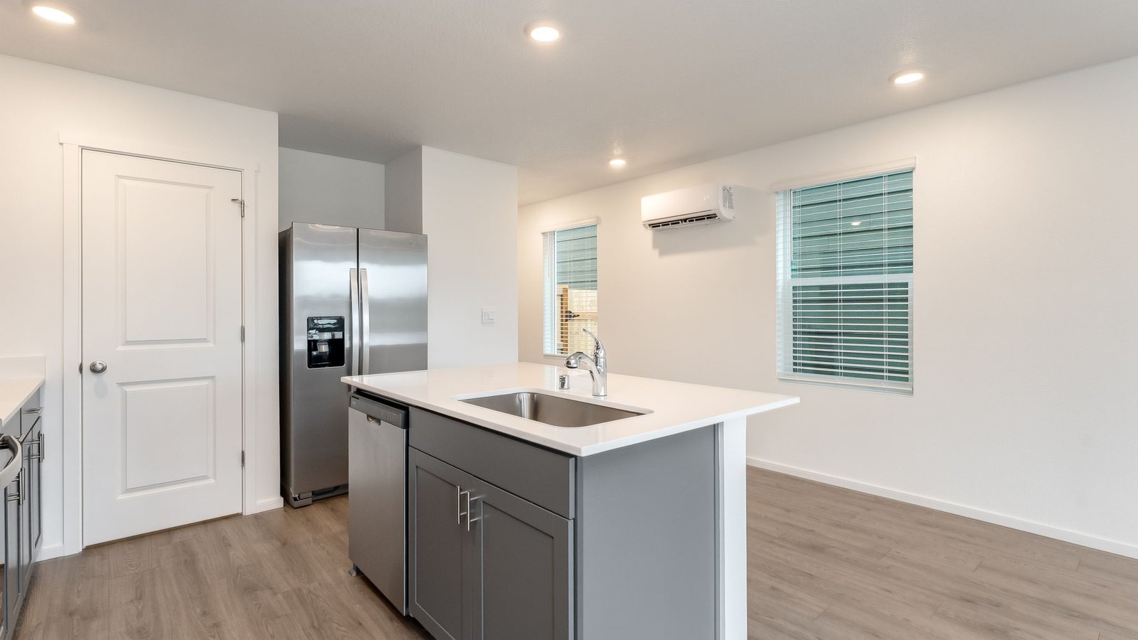 Kitchen with shaker cabinets, quartz counters, stainless steel appliances, pantry, and an island with a breakfast bar