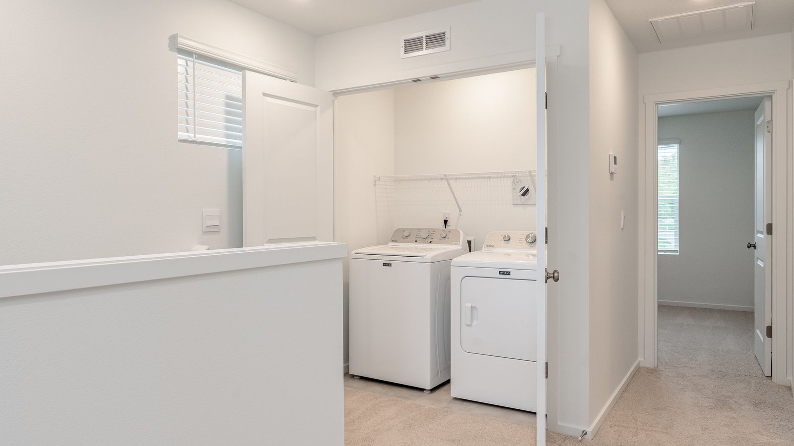 Laundry closet with wire shelves and washer and dryer hookups