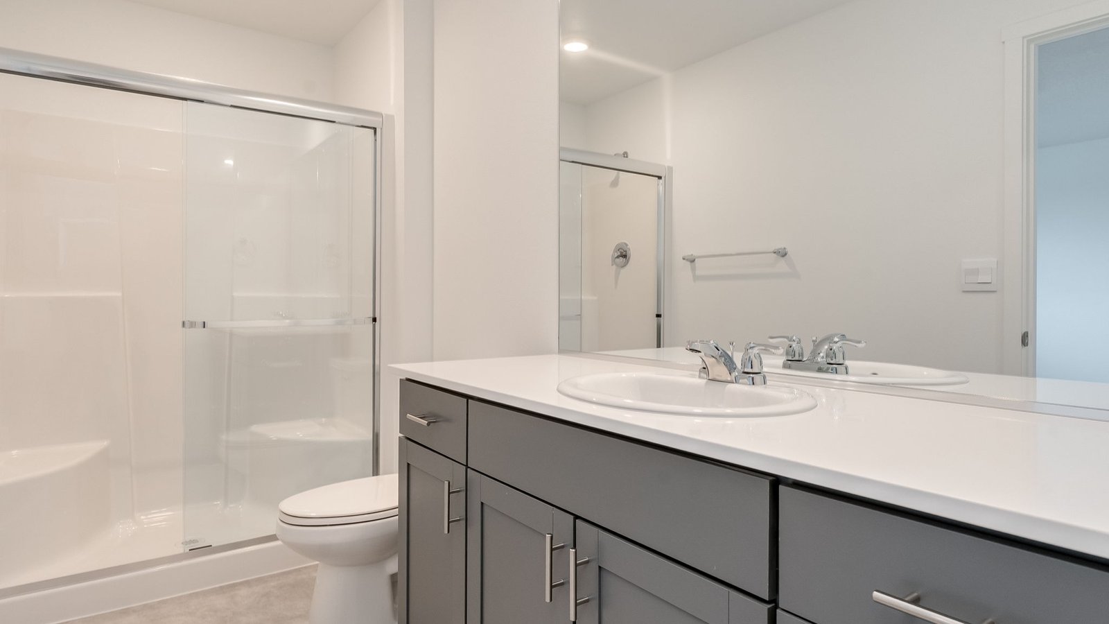 Primary bathroom with quartz counters and a walk-in shower