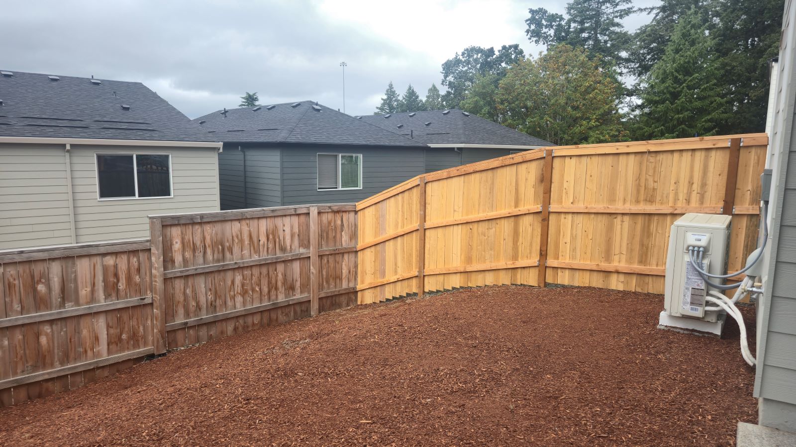 fully fenced backyard with sod lawn and a patio