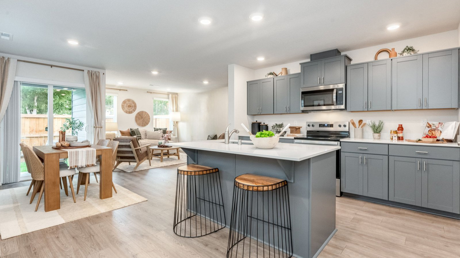 Kitchen with shaker cabinets, quartz counters, stainless steel appliances, pantry, and an island with a breakfast bar