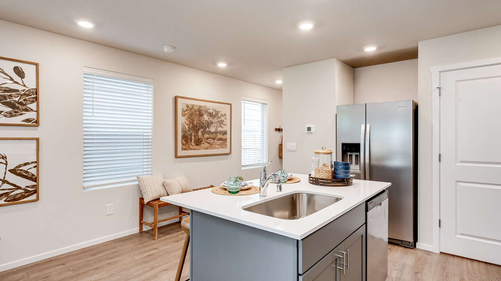 Kitchen with shaker cabinets, quartz counters, stainless steel appliances, pantry, and an island with a breakfast bar