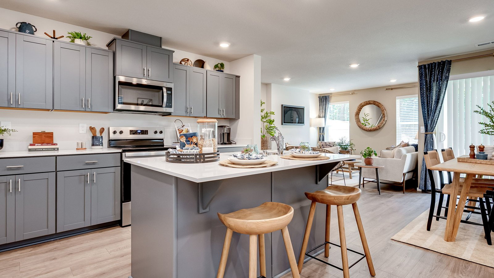 Kitchen with shaker cabinets, quartz counters, stainless steel appliances, pantry, and an island with a breakfast bar