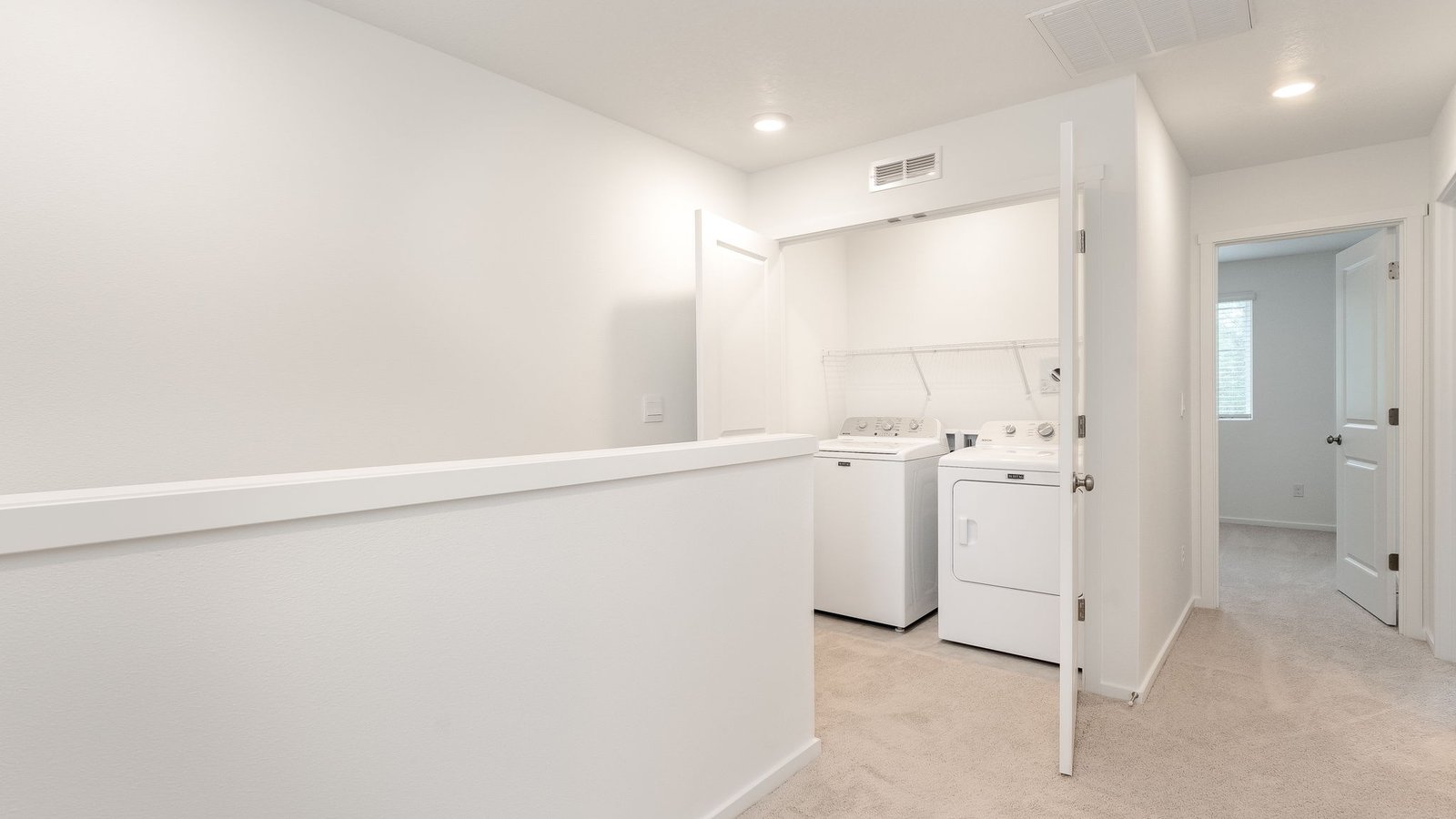 Laundry closet with wire shelves and washer and dryer hookups