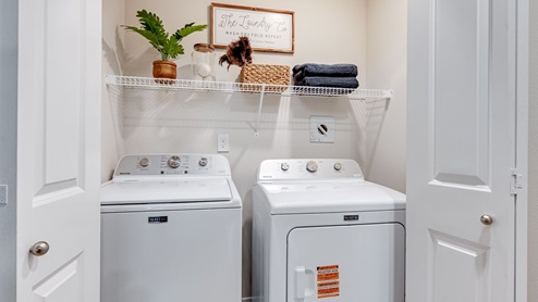 Laundry closet with wire shelves and washer and dryer hookups