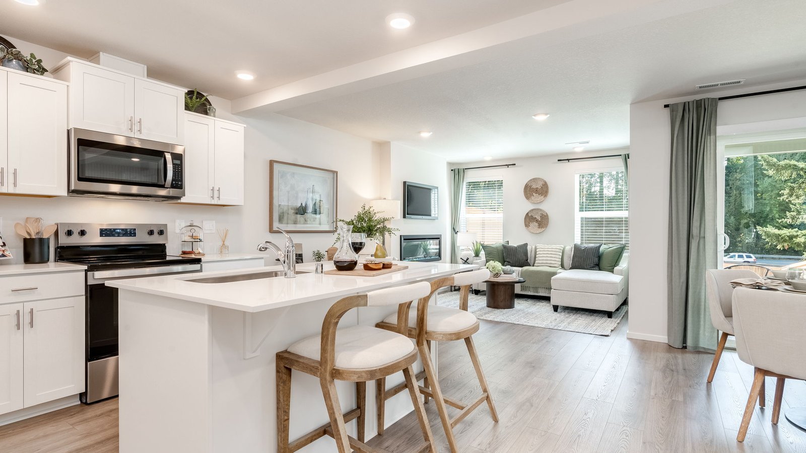 Kitchen with shaker cabinets, quartz counters, stainless steel appliances, pantry, and an island with a breakfast bar