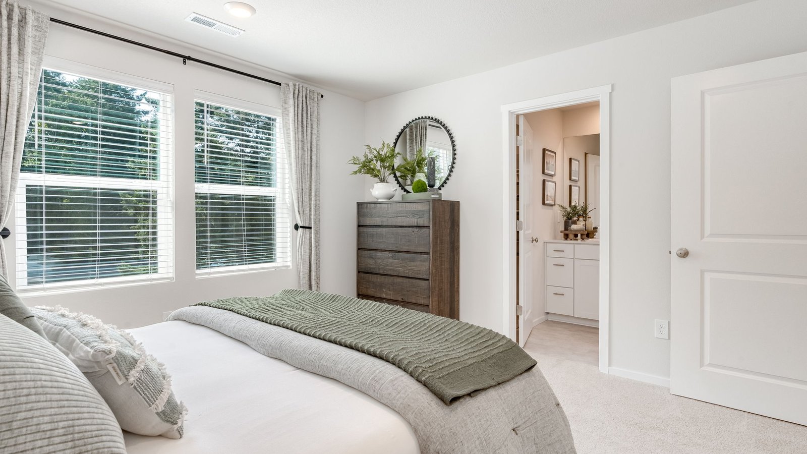 Primary bedroom with wall-to-wall carpet, a walk-in closet and an attached bathroom