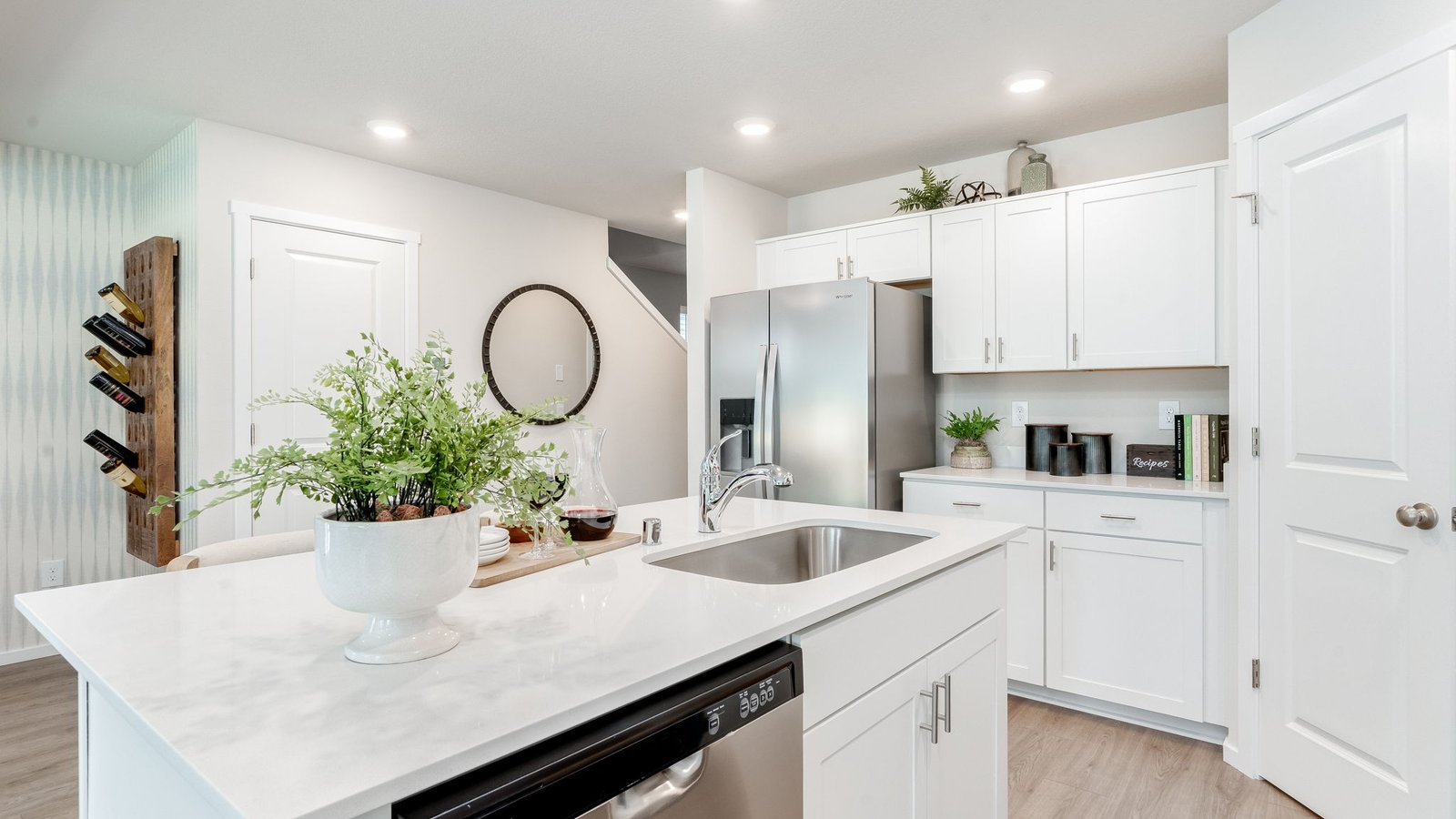 Kitchen with shaker cabinets, quartz counters, stainless steel appliances, pantry, and an island with a breakfast bar