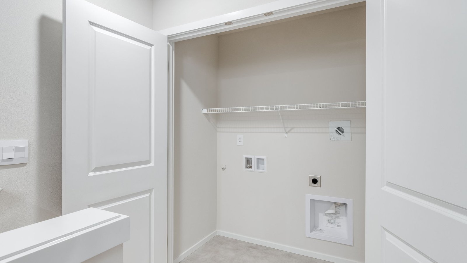 Laundry closet with wire shelves and washer and dryer hookups
