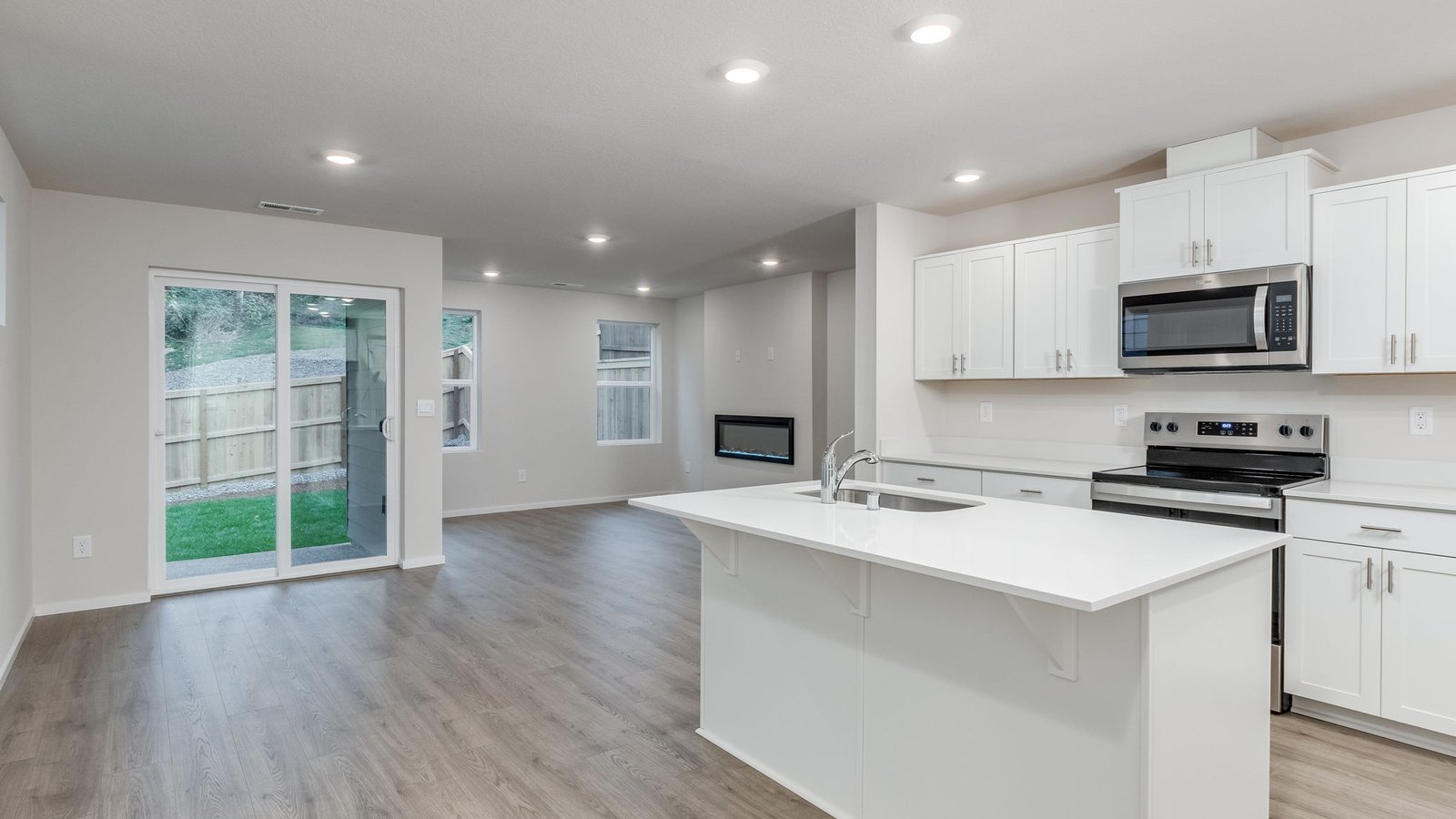 Kitchen with shaker cabinets, quartz counters, stainless steel appliances, pantry, and an island with a breakfast bar