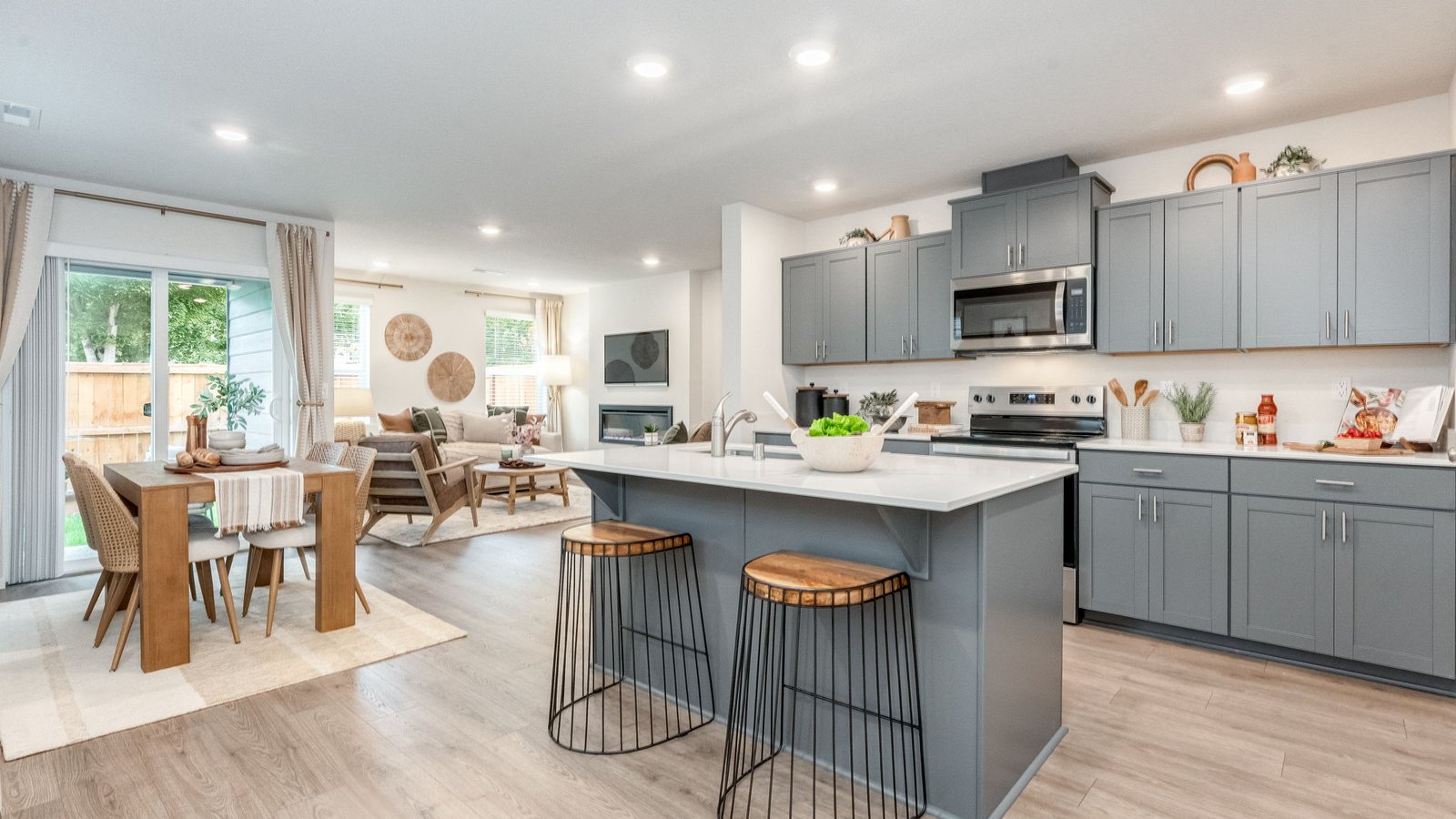 Kitchen with shaker cabinets, quartz counters, stainless steel appliances, pantry, and an island with a breakfast bar