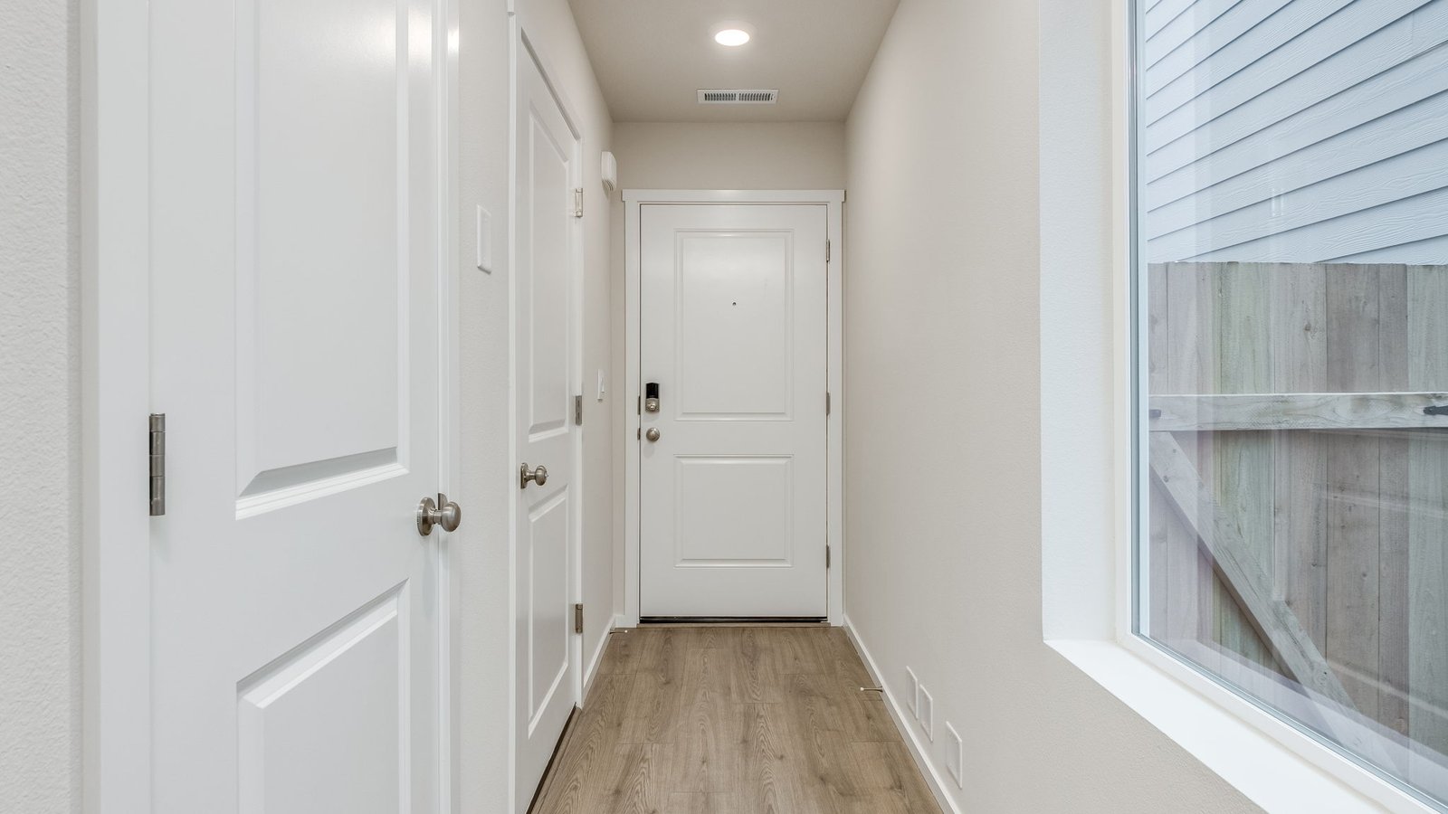Entryway with a coat closet and laminate flooring