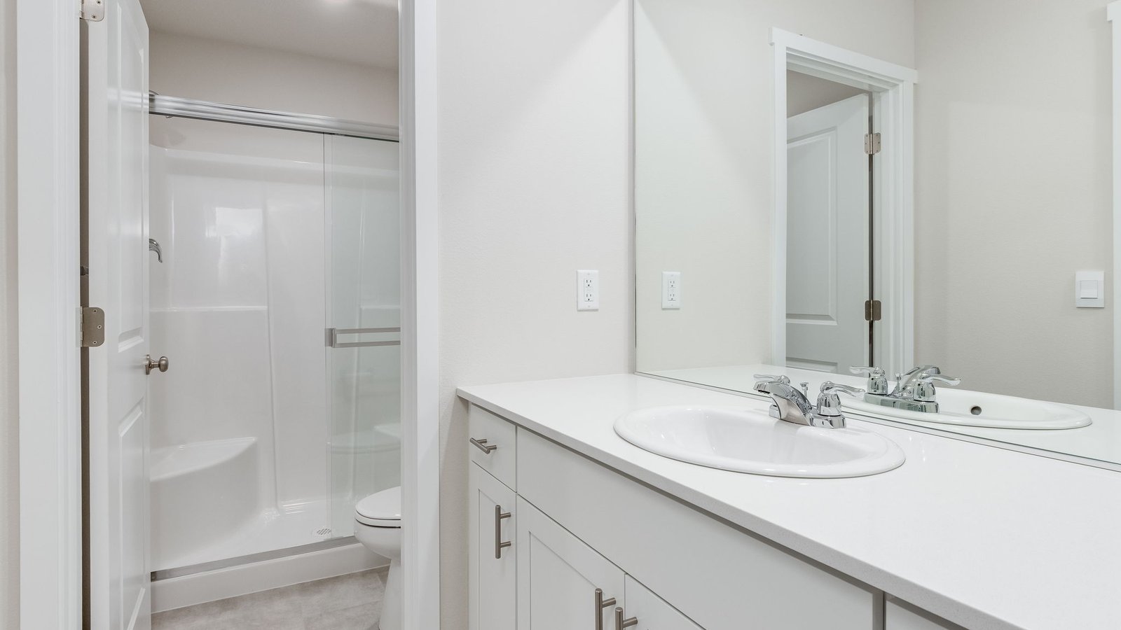 Primary bathroom with quartz counters and a walk-in shower