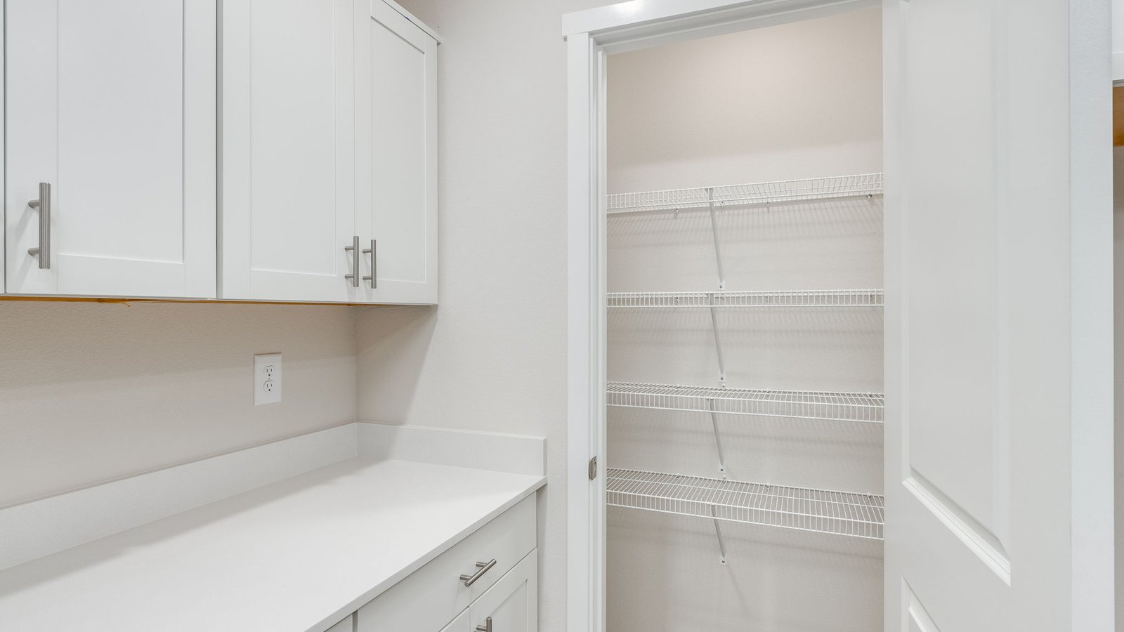 Kitchen with shaker cabinets, quartz counters, stainless steel appliances, pantry, and an island with a breakfast bar