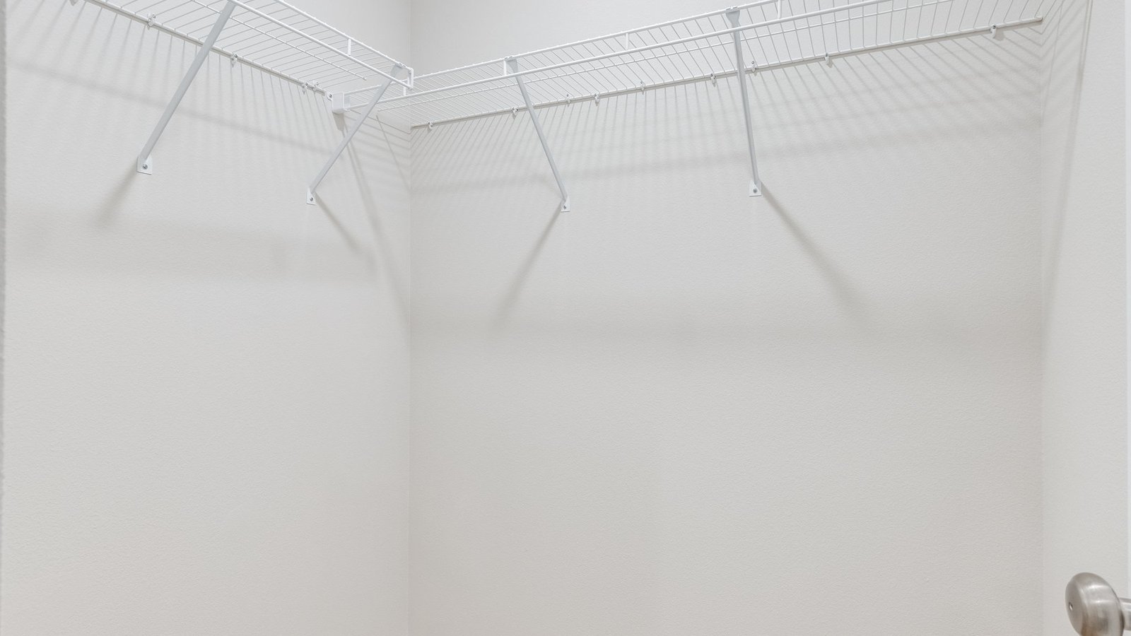 Primary bedroom walk-in closet with wire shelves