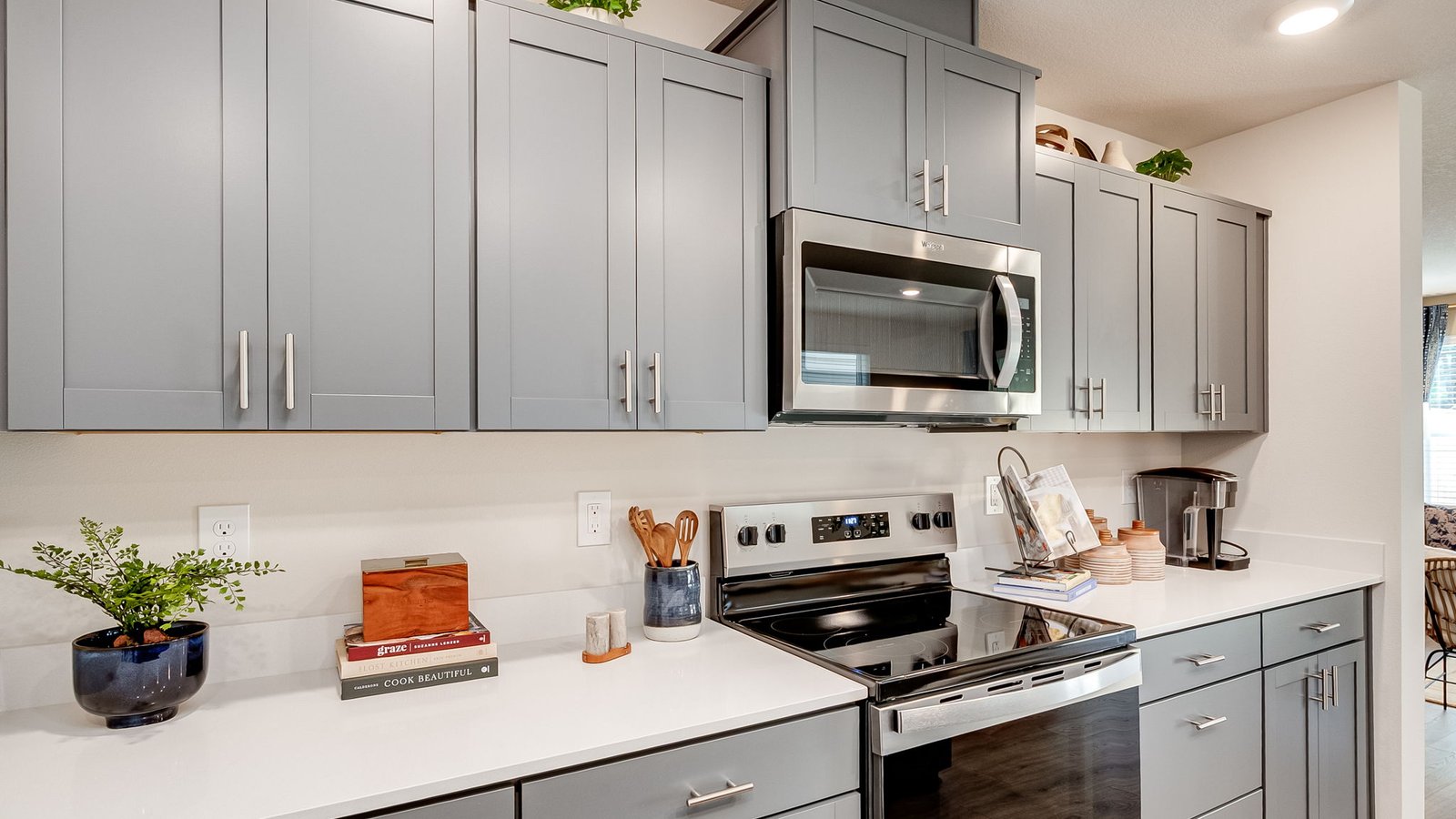 Kitchen with shaker cabinets, quartz counters, stainless steel appliances, pantry, and an island with a breakfast bar