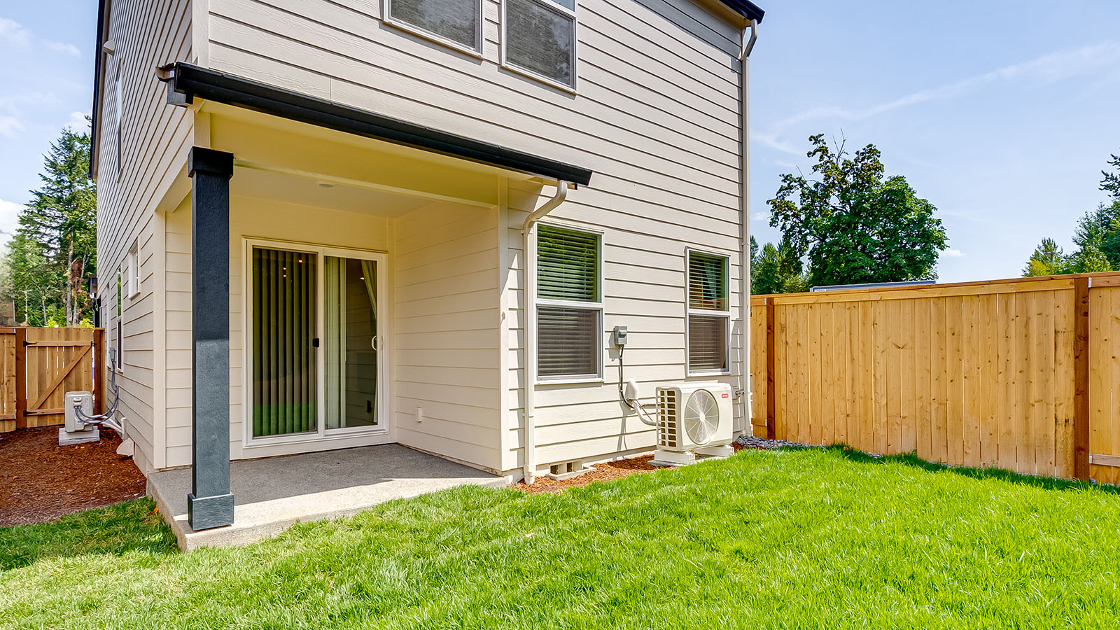 fully fenced backyard with sod lawn and a patio