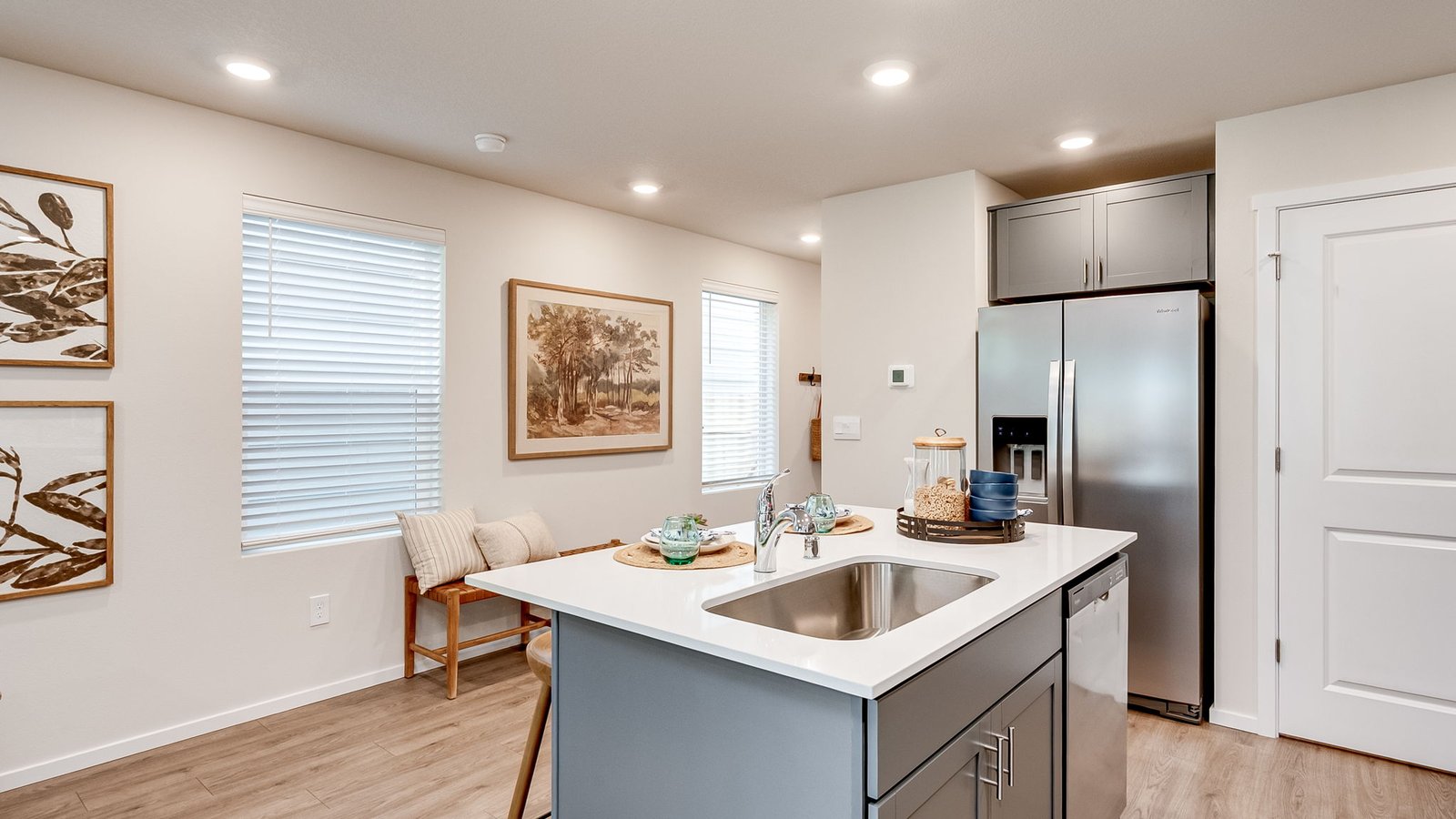 Kitchen with shaker cabinets, quartz counters, stainless steel appliances, pantry, and an island with a breakfast bar