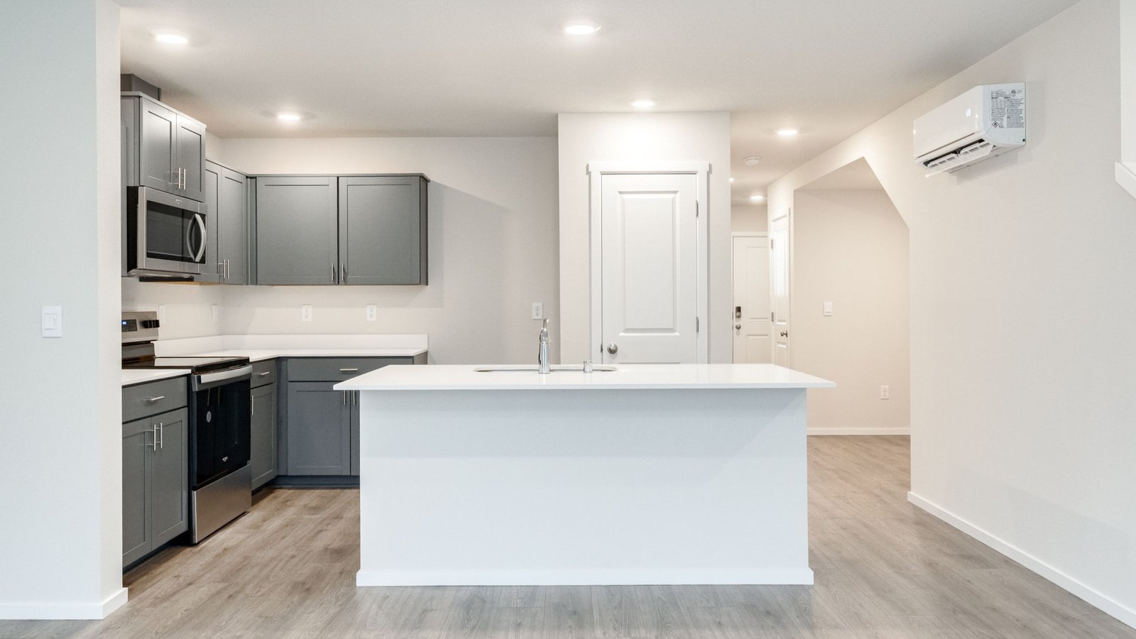Kitchen with shaker cabinets, quartz counters, stainless steel appliances, pantry, and an island with a breakfast bar