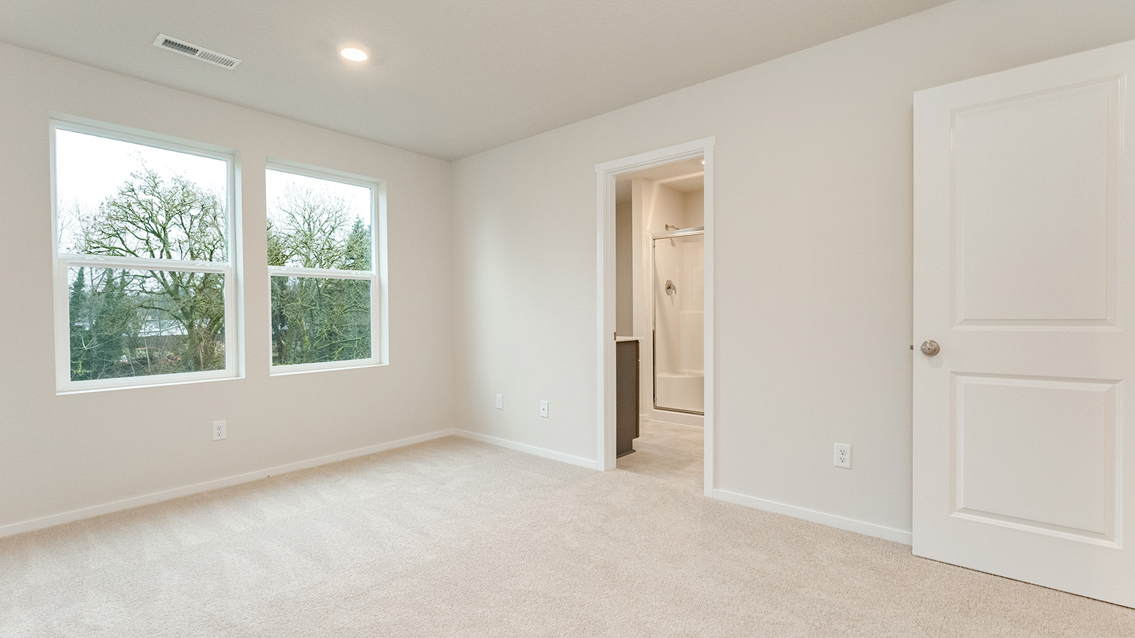 Primary bedroom with wall-to-wall carpet, a walk-in closet and an attached bathroom