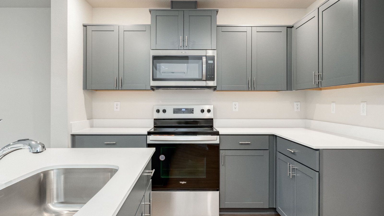Kitchen with shaker cabinets, quartz counters, stainless steel appliances, pantry, and an island with a breakfast bar