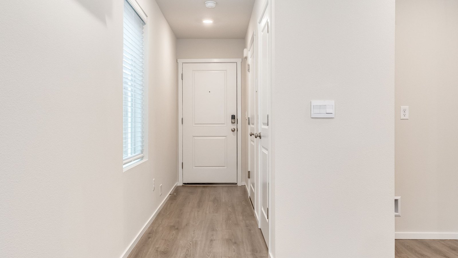 Entryway with a coat closet and laminate flooring