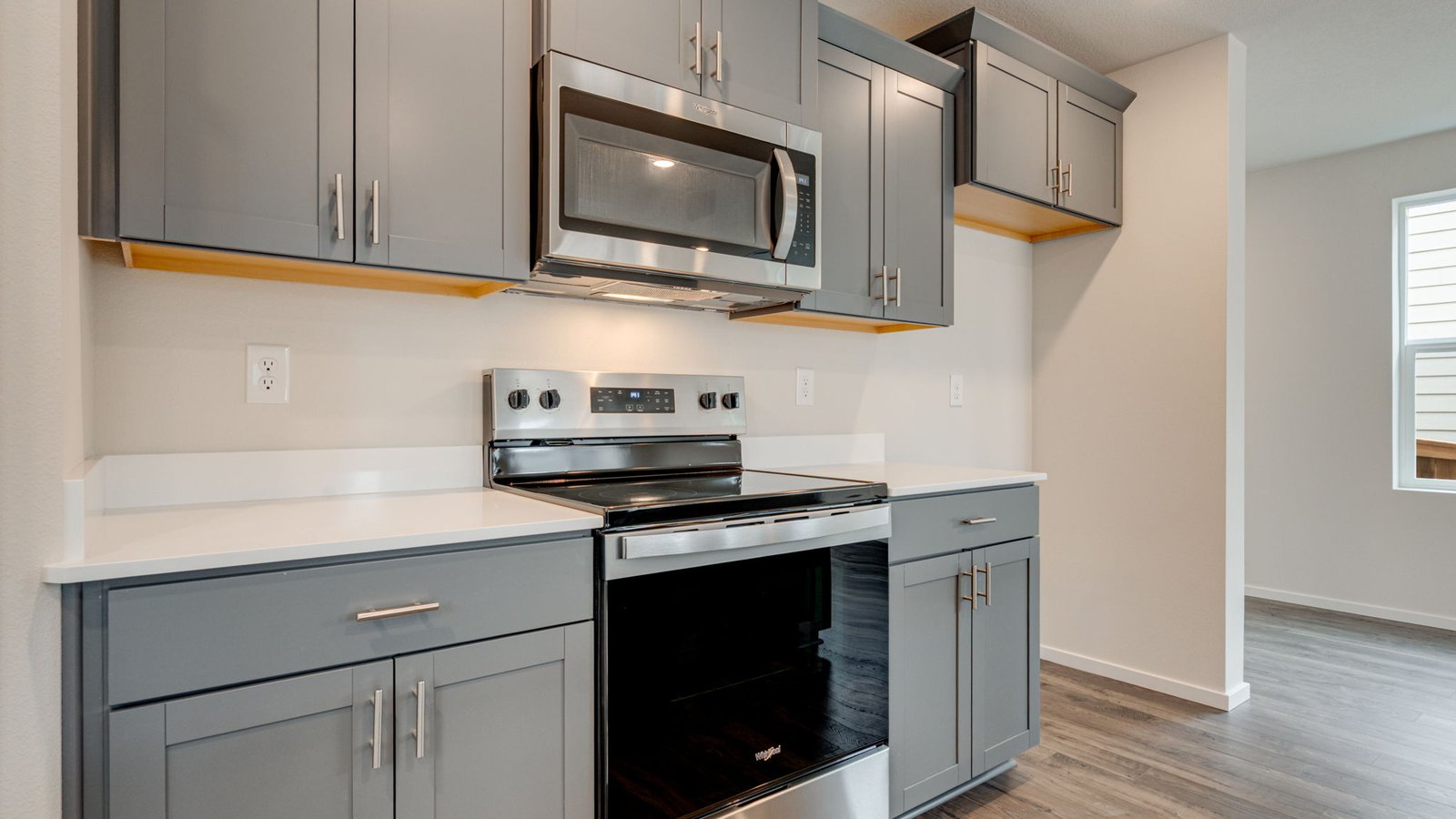 Kitchen with shaker cabinets, quartz counters, stainless steel appliances, pantry, and an island with a breakfast bar