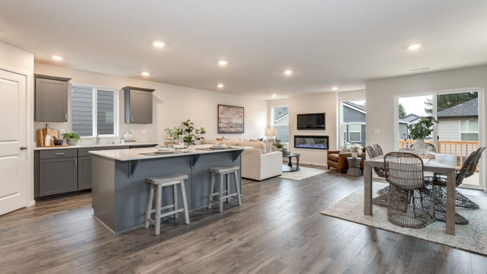 Kitchen with shaker cabinets, quartz counters, stainless steel appliances, pantry, and an island with a breakfast bar