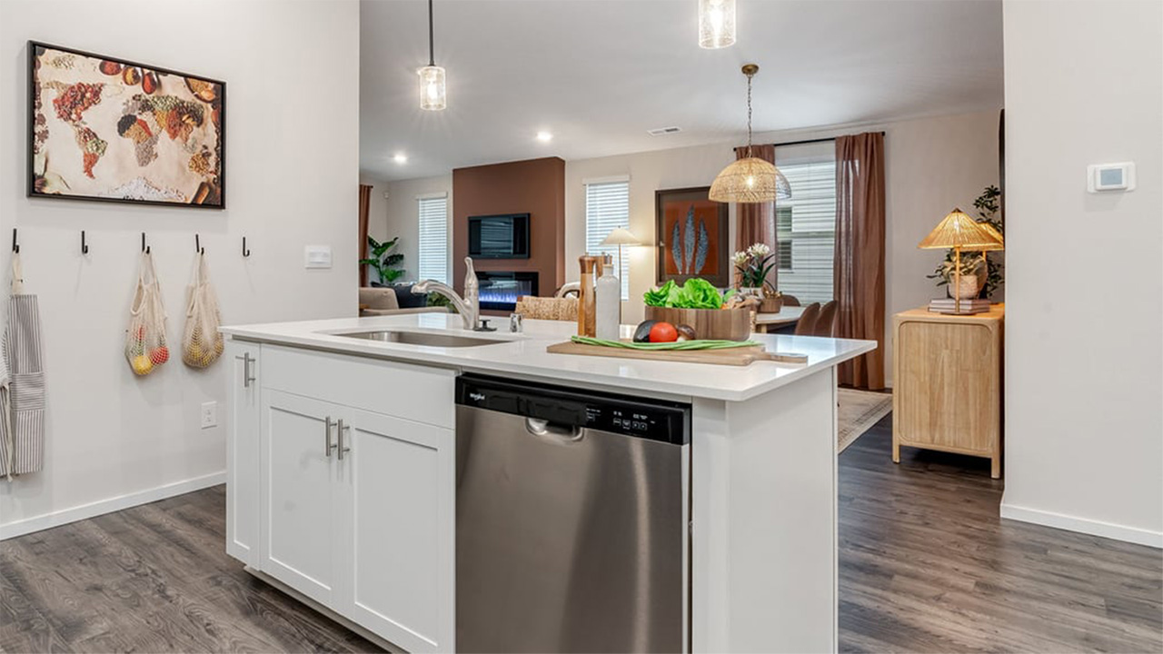 Kitchen with shaker cabinets, quartz counters, stainless steel appliances, pantry, and an island with a breakfast bar