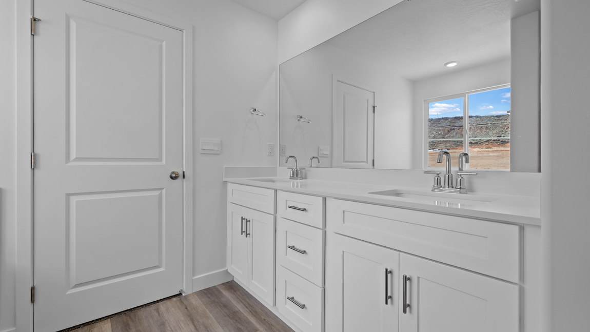 Large primary bathroom with quartz countertops, double sink vanity, and separate walk in shower and garden tub with window